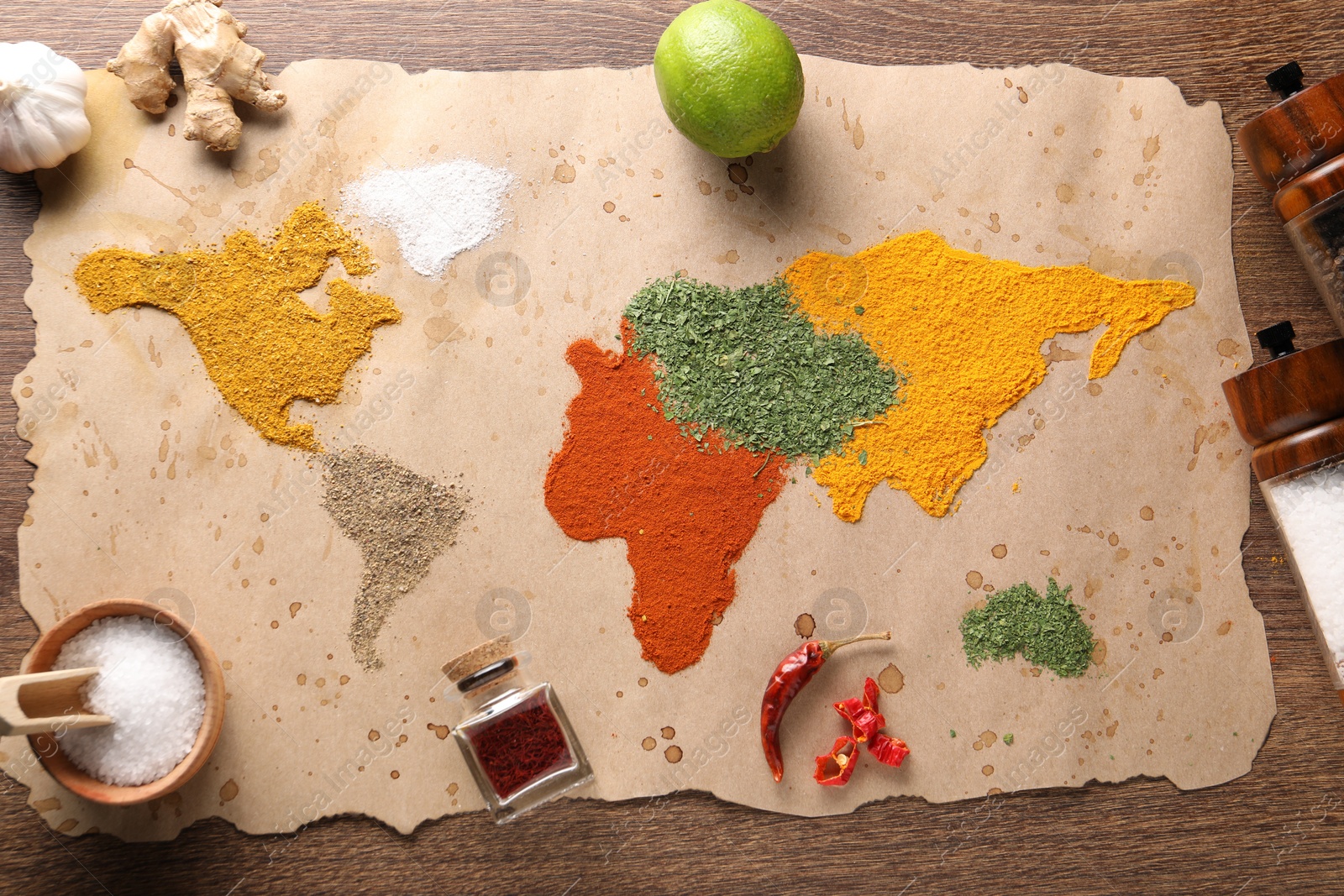 Photo of World map of different spices and products on wooden table, top view