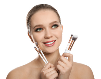 Beautiful woman with makeup brushes on white background