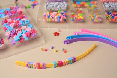 Photo of Handmade jewelry kit for kids. Colorful beads, and wristbands on beige background