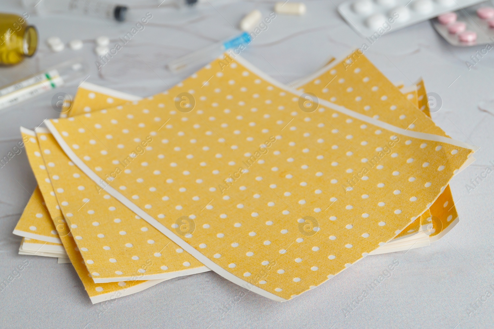 Photo of Yellow mustard plaster on light gray table, closeup