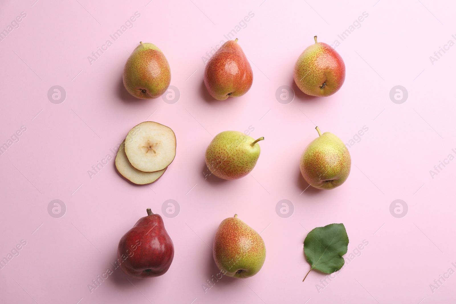 Photo of Ripe juicy pears with leaf on pink background, flat lay