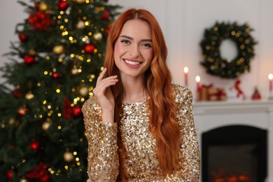 Happy young woman in room decorated for Christmas