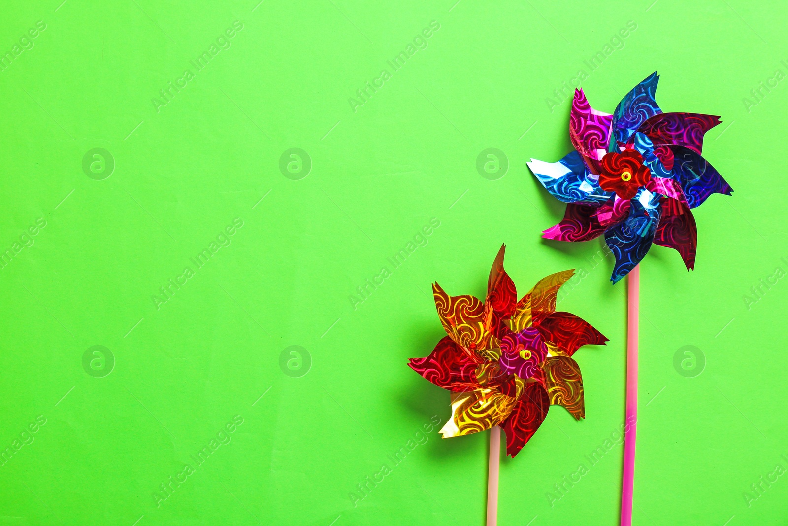 Photo of Flat lay composition with pinwheels on color background