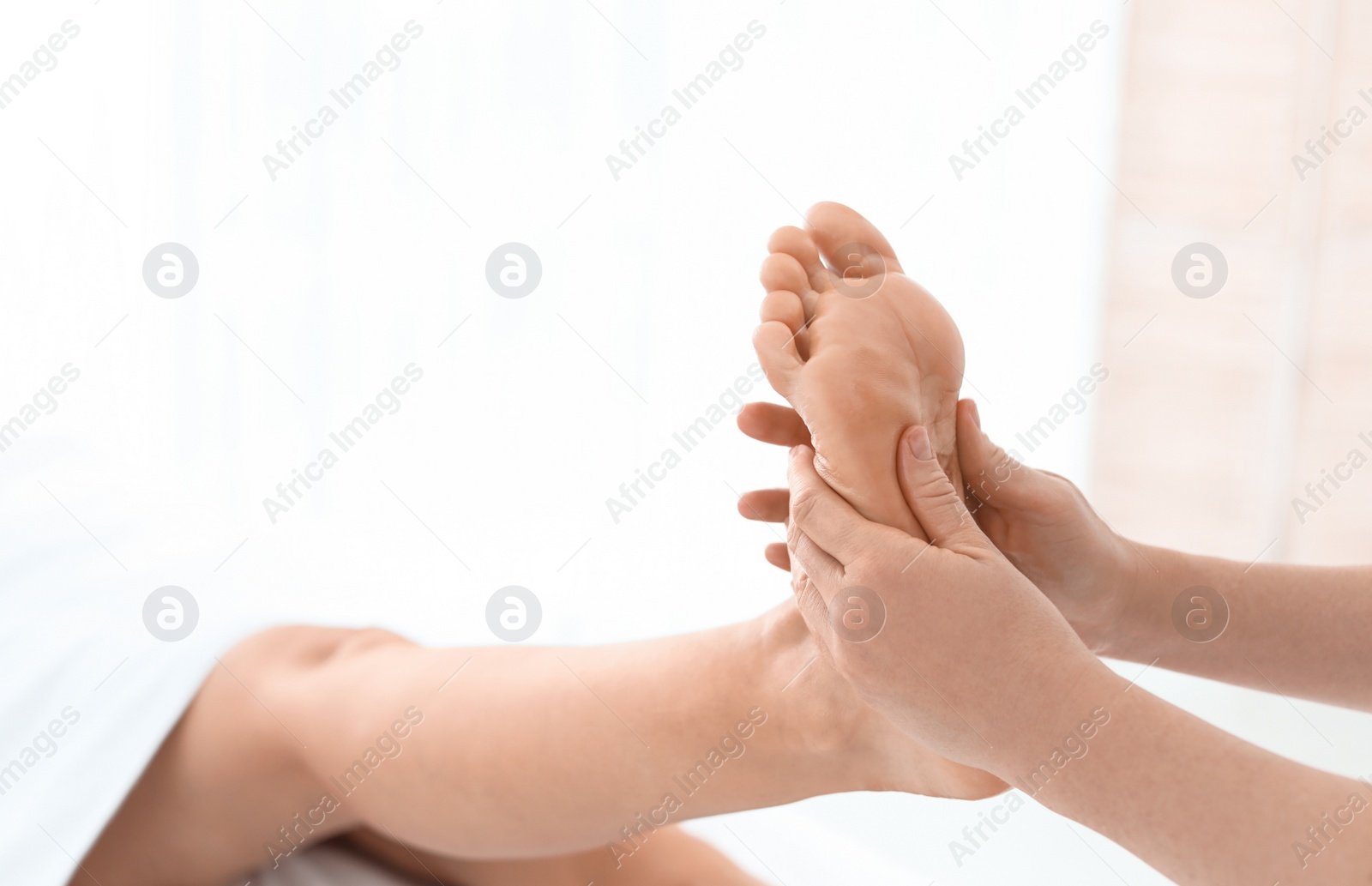 Photo of Woman receiving foot massage in wellness center, closeup