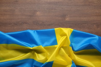 Flag of Sweden on wooden background, top view. Space for text