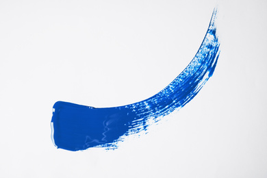 Photo of Paint stroke on white background background, top view. Color of the year 2020 (Classic blue)
