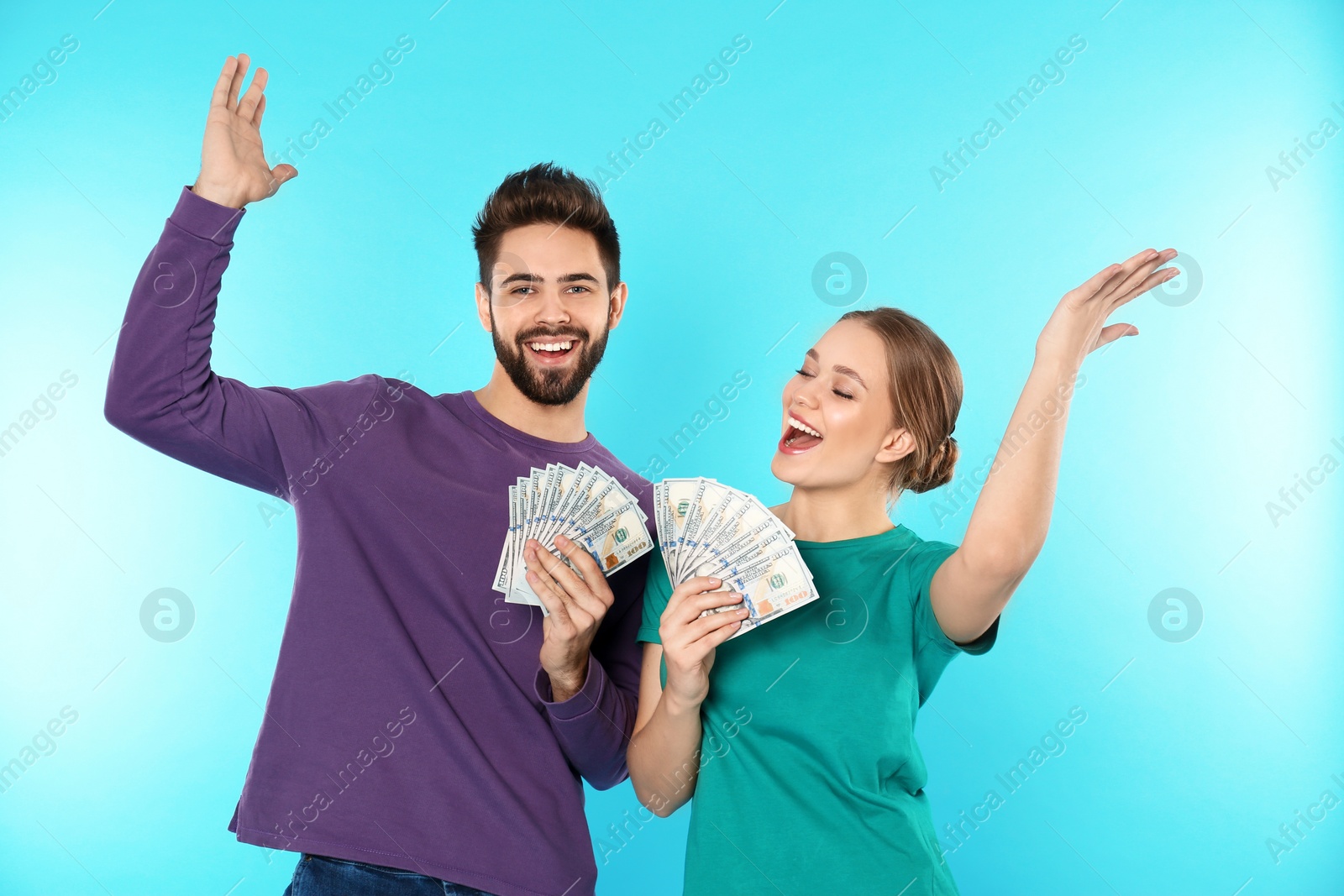 Photo of Happy young couple with money on color background