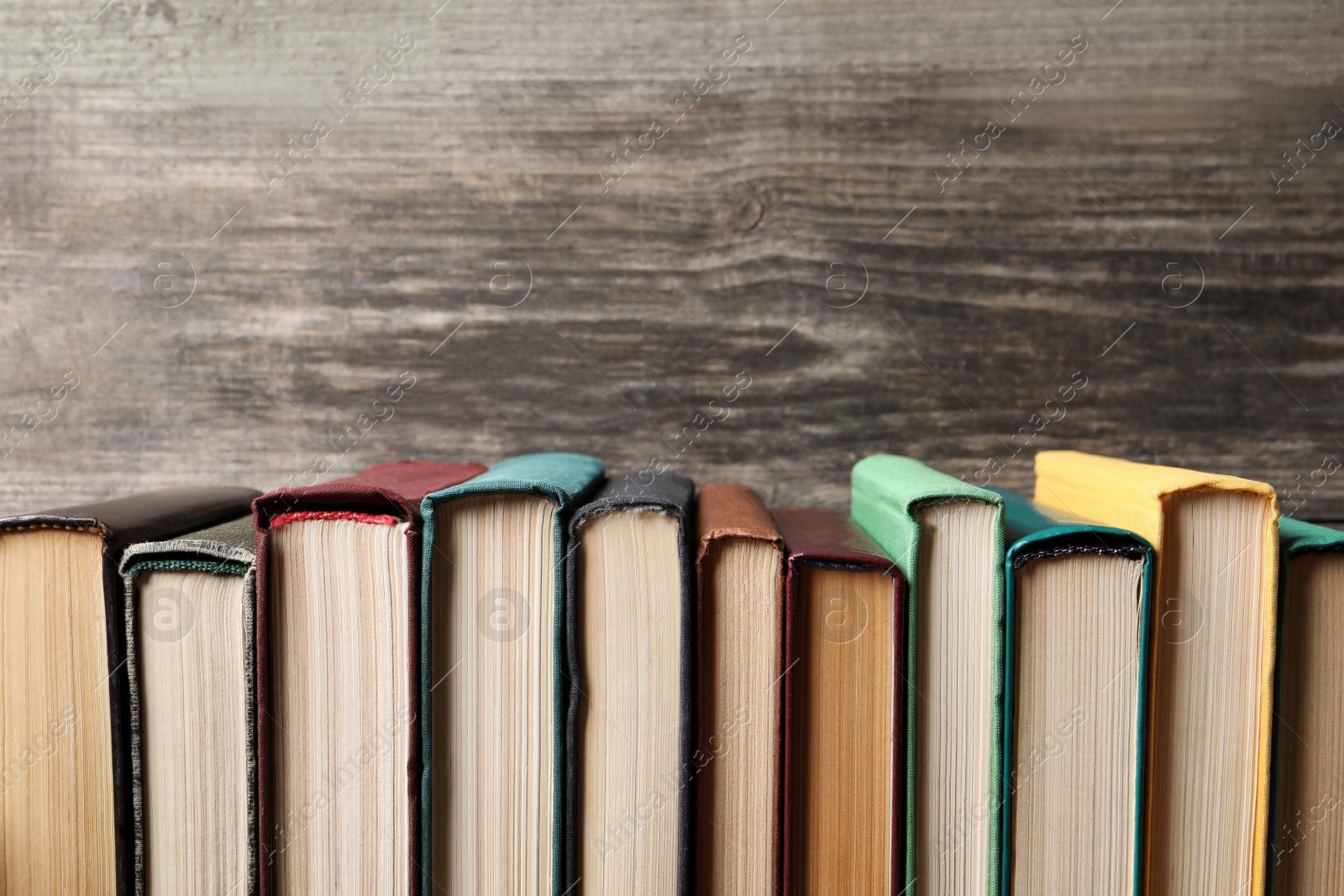 Photo of Different old hardcover books on wooden table, space for text