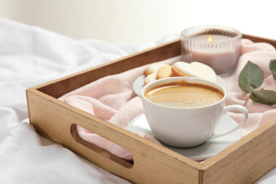 Photo of Wooden tray with coffee and cookies on bed. Romantic breakfast