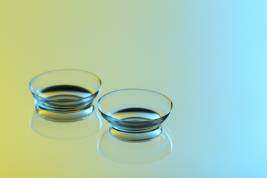 Photo of Pair of contact lenses on mirror surface. Space for text
