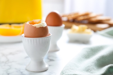 Photo of Cups with soft boiled eggs on marble table, space for text. Healthy breakfast
