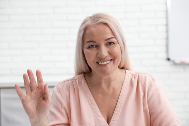 Mature woman using video chat indoors, view from web camera