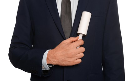 Photo of Man cleaning jacket with adhesive lint roller on white background, closeup