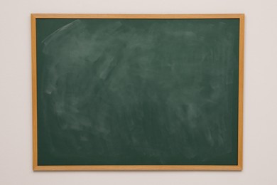 Clean green chalkboard hanging on grey wall