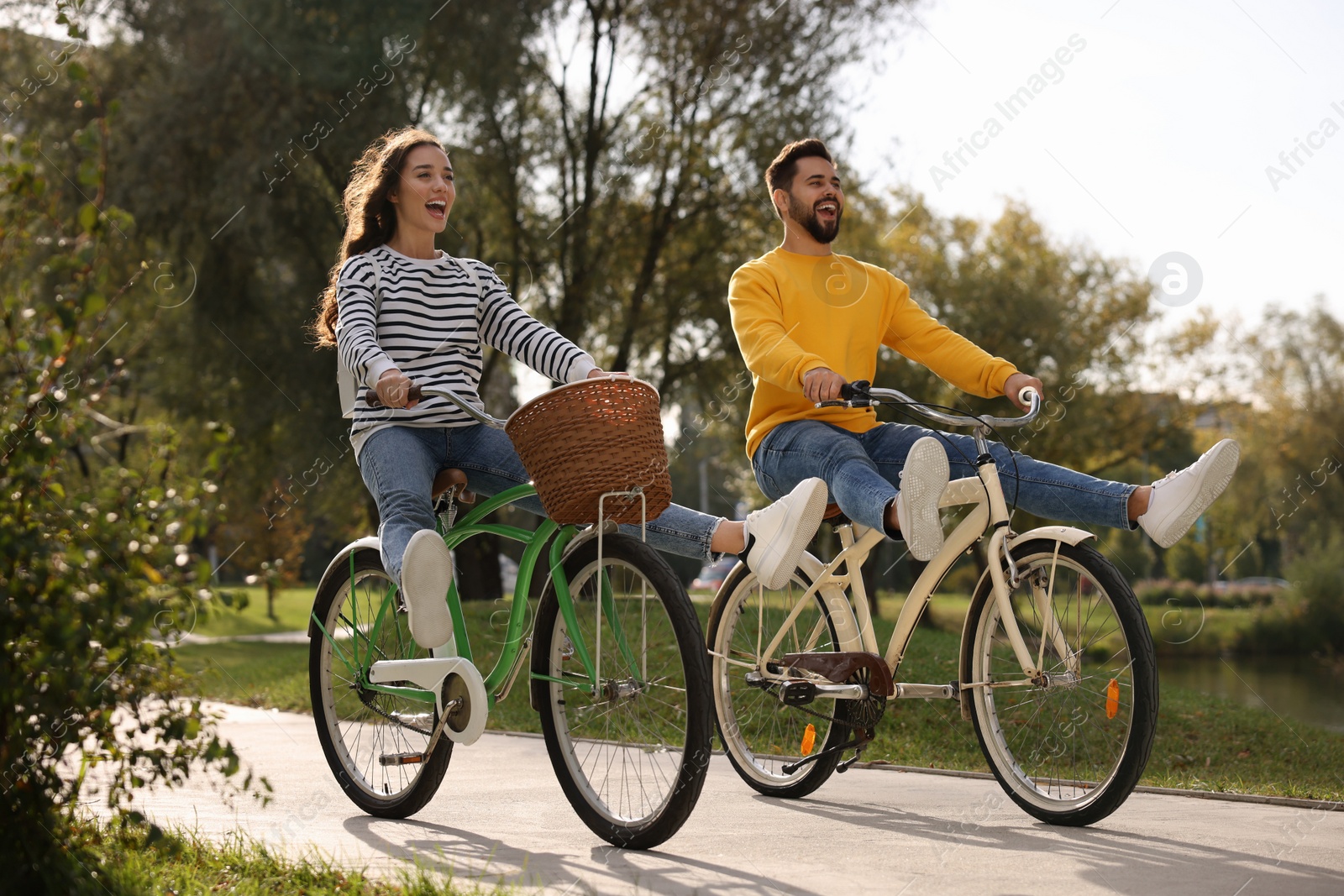 Photo of Beautiful young couple riding bicycles in park