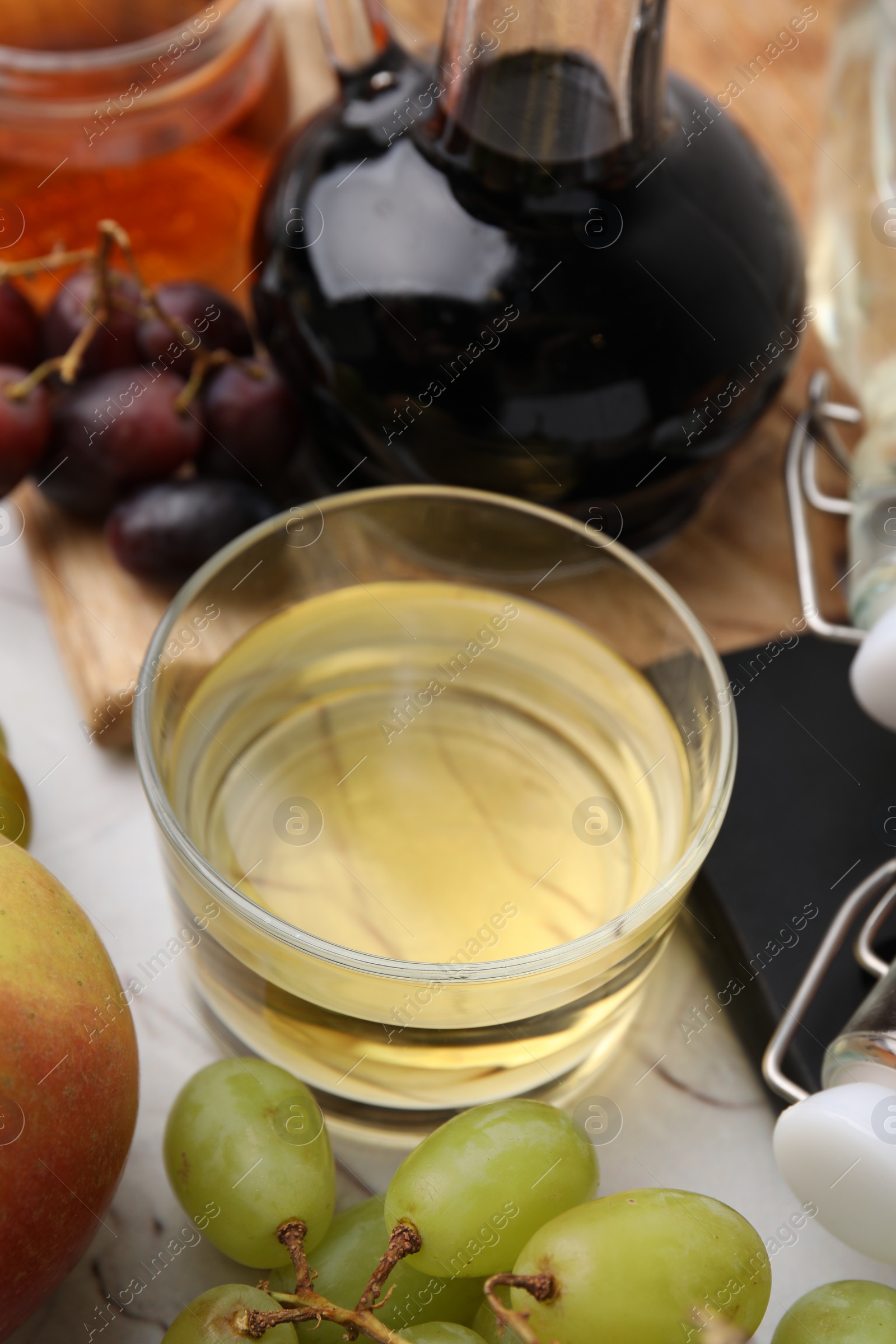 Photo of Different types of vinegar and fresh fruits on table