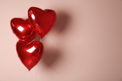 Photo of Red heart shaped balloons on pink background, space for text. Valentine's Day celebration