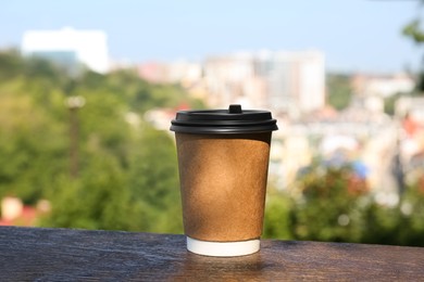 Paper cup with hot cofffee outdoors. Takeaway drink