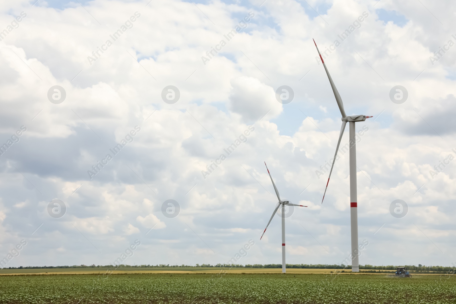 Photo of Modern wind turbines in field on cloudy day. Alternative energy source