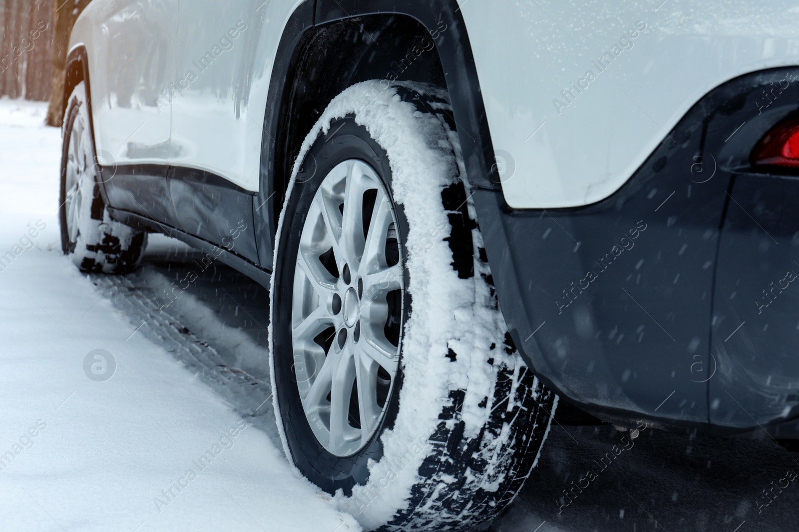 Photo of Modern car on snowy road, closeup view. Winter season