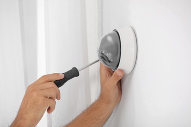 Photo of Technician installing CCTV camera on wall, closeup