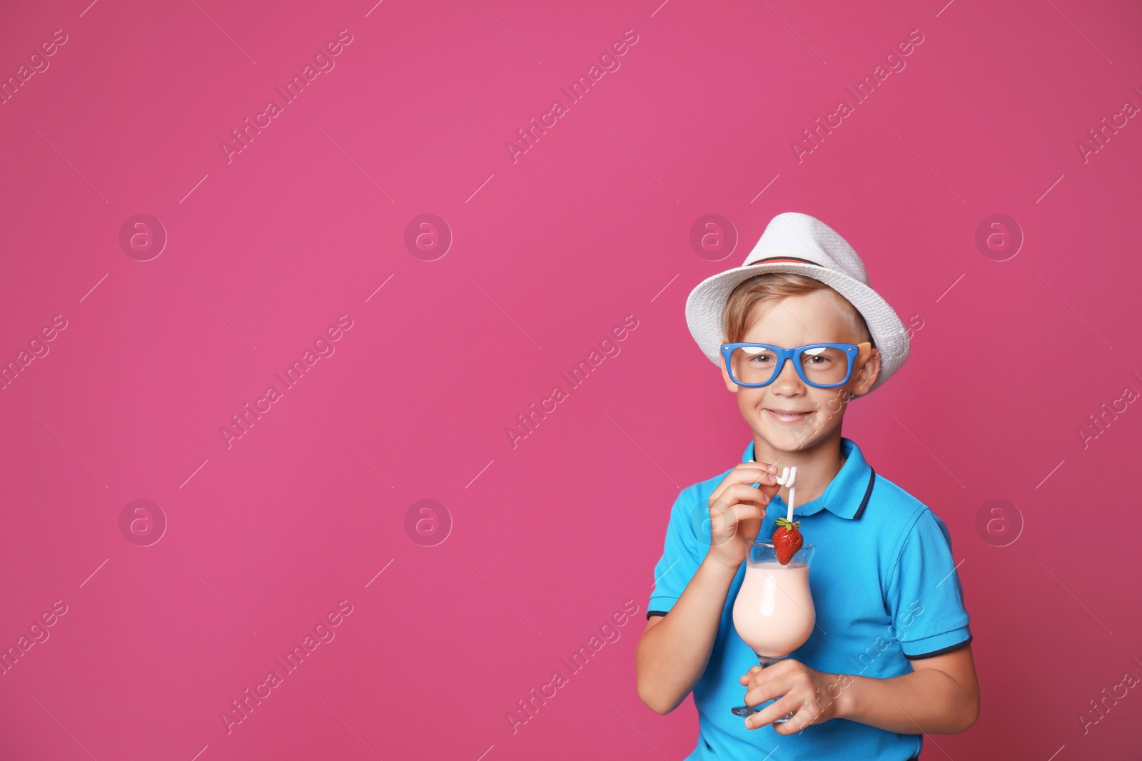 Photo of Little boy with glass of milk shake on color background