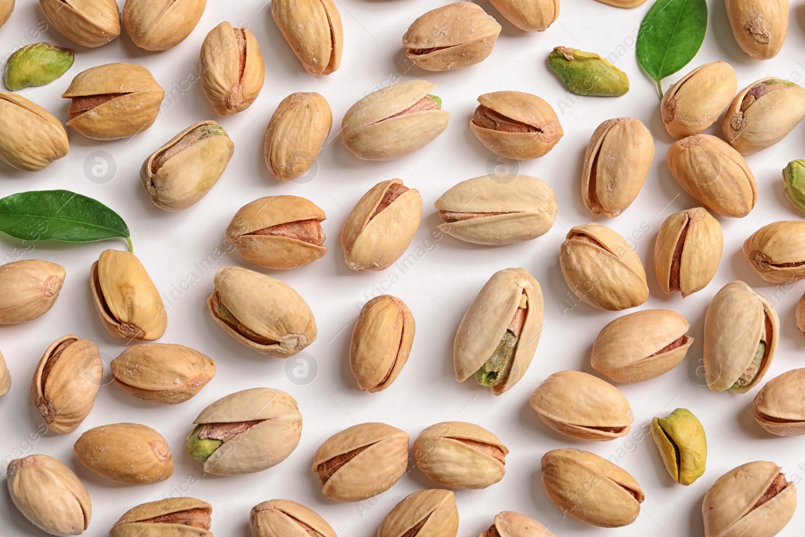 Photo of Organic pistachio nuts on white background, flat lay