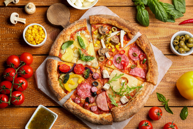 Photo of Flat lay composition with slices of different delicious pizzas on wooden table