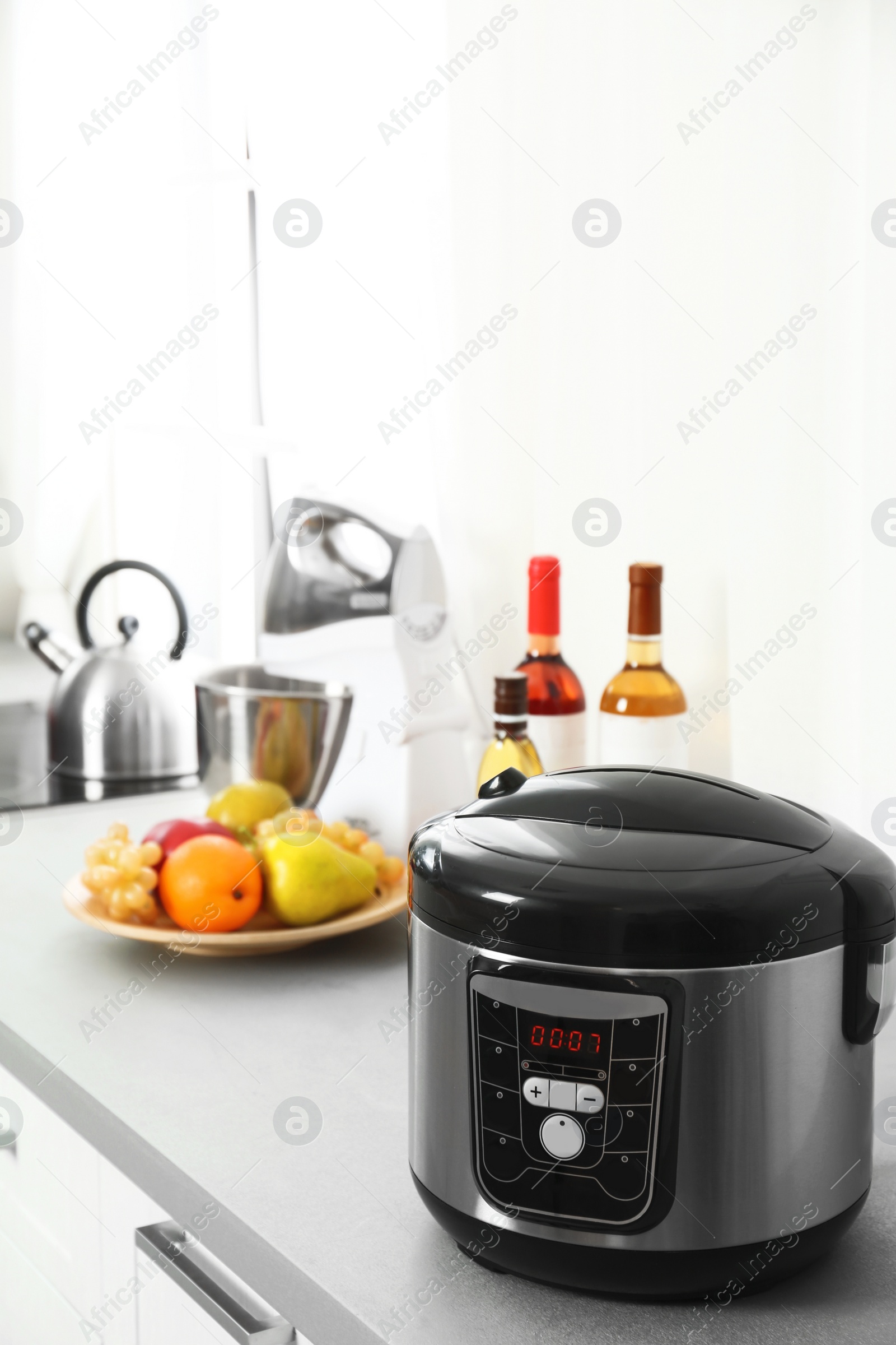 Photo of Modern multi cooker and products on table in kitchen. Space for text