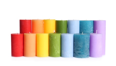 Different colorful wax candles on white background