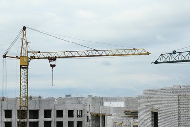 Photo of Construction site with tower crane near unfinished building