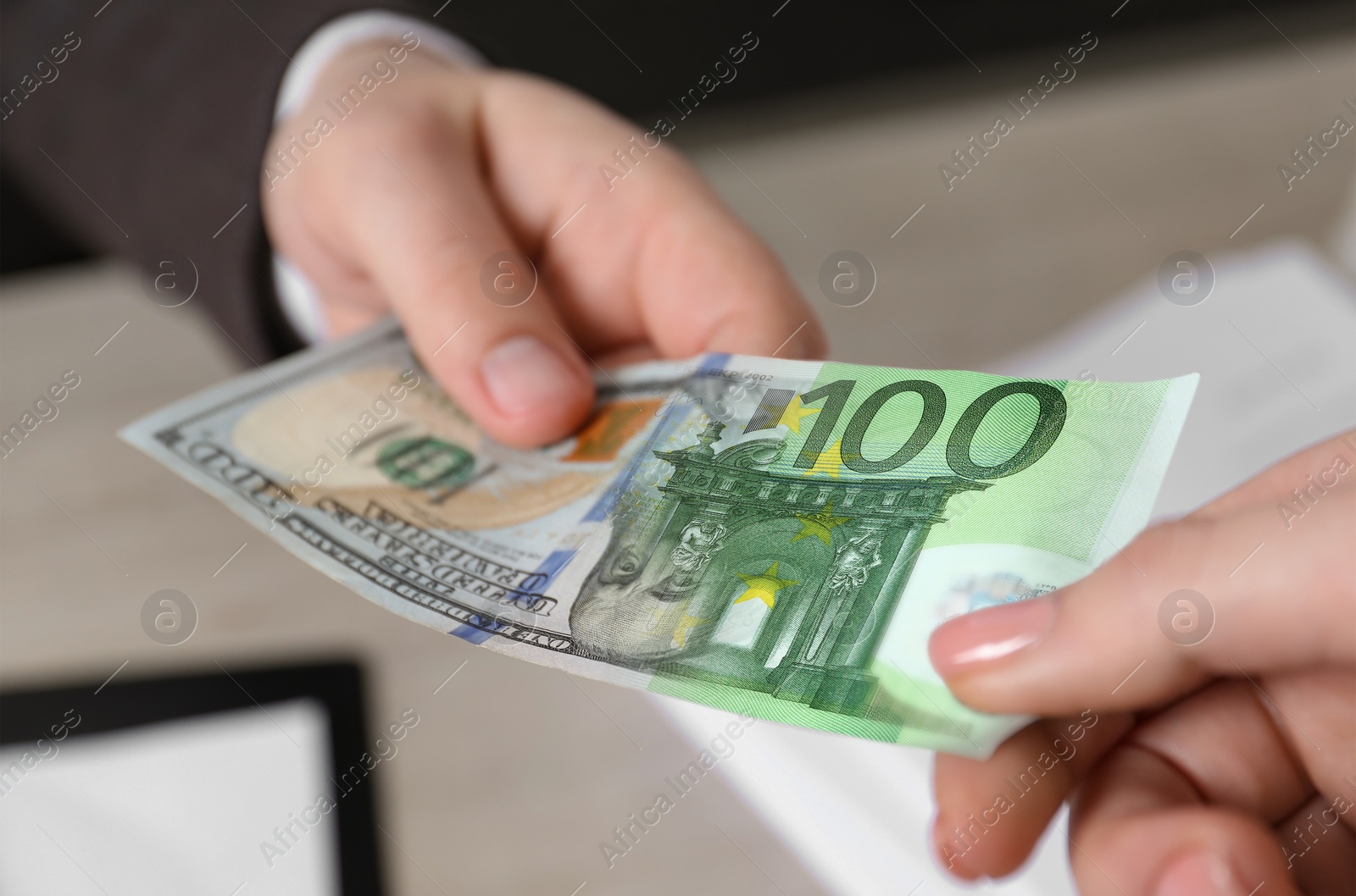 Image of Currency exchange. Man giving money to woman indoors, closeup. Combined euro and dollar banknote design