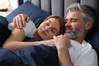 Photo of Lovely mature couple sleeping together in bed at home