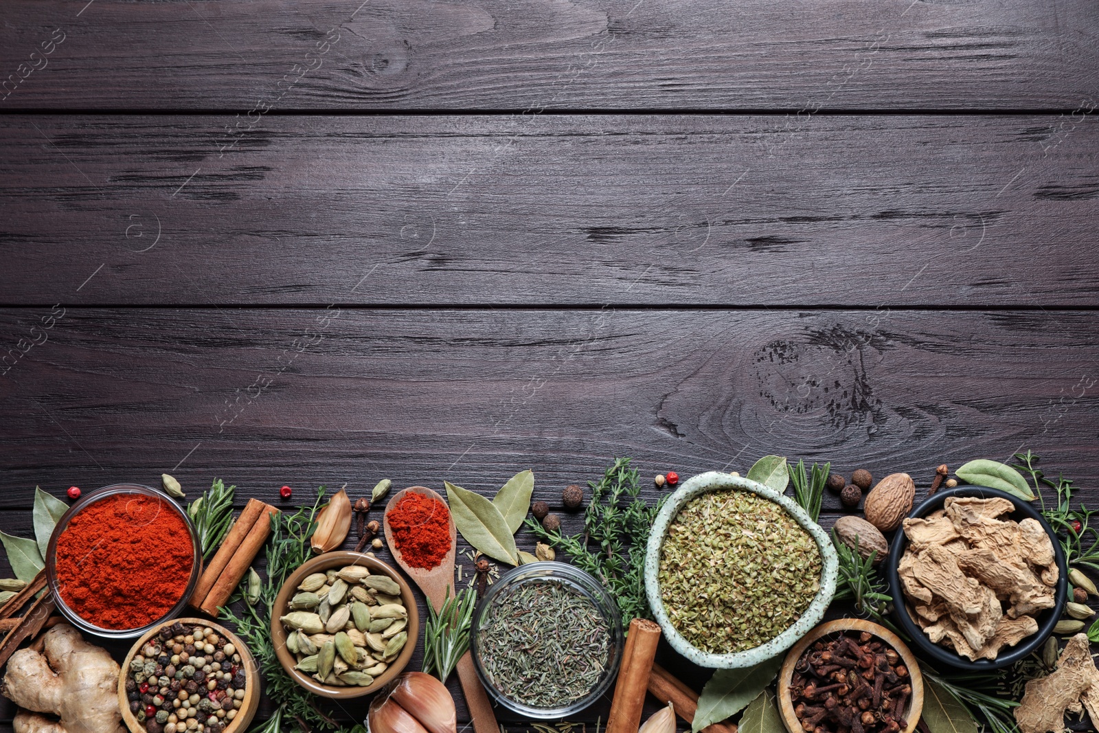 Photo of Different natural spices and herbs on wooden table, flat lay. Space for text