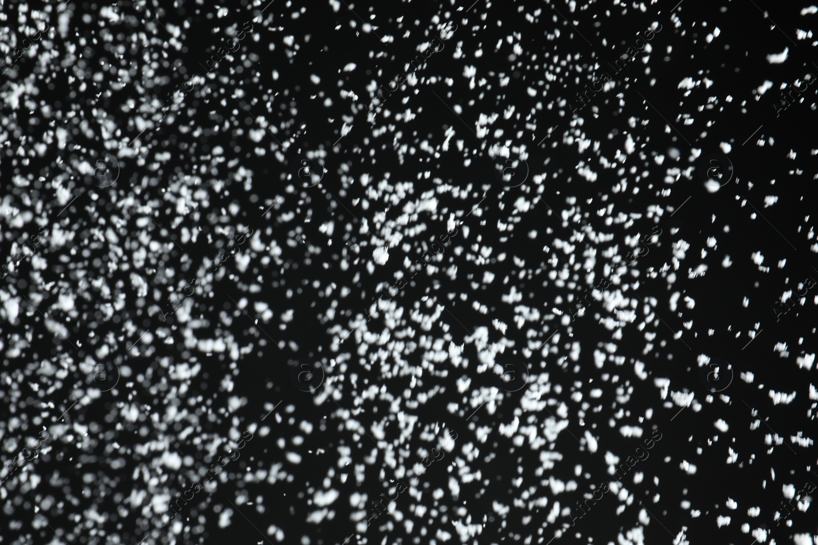 Photo of White snow falling down on black background