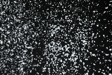 Photo of White snow falling down on black background