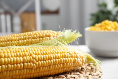Photo of Fresh ripe corn cobs on table, closeup