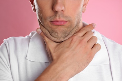 Young man with double chin on pink background, closeup