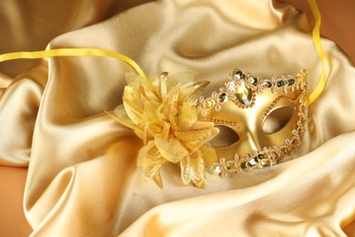 Photo of Beautifully decorated face mask on golden fabric. Theatrical performance
