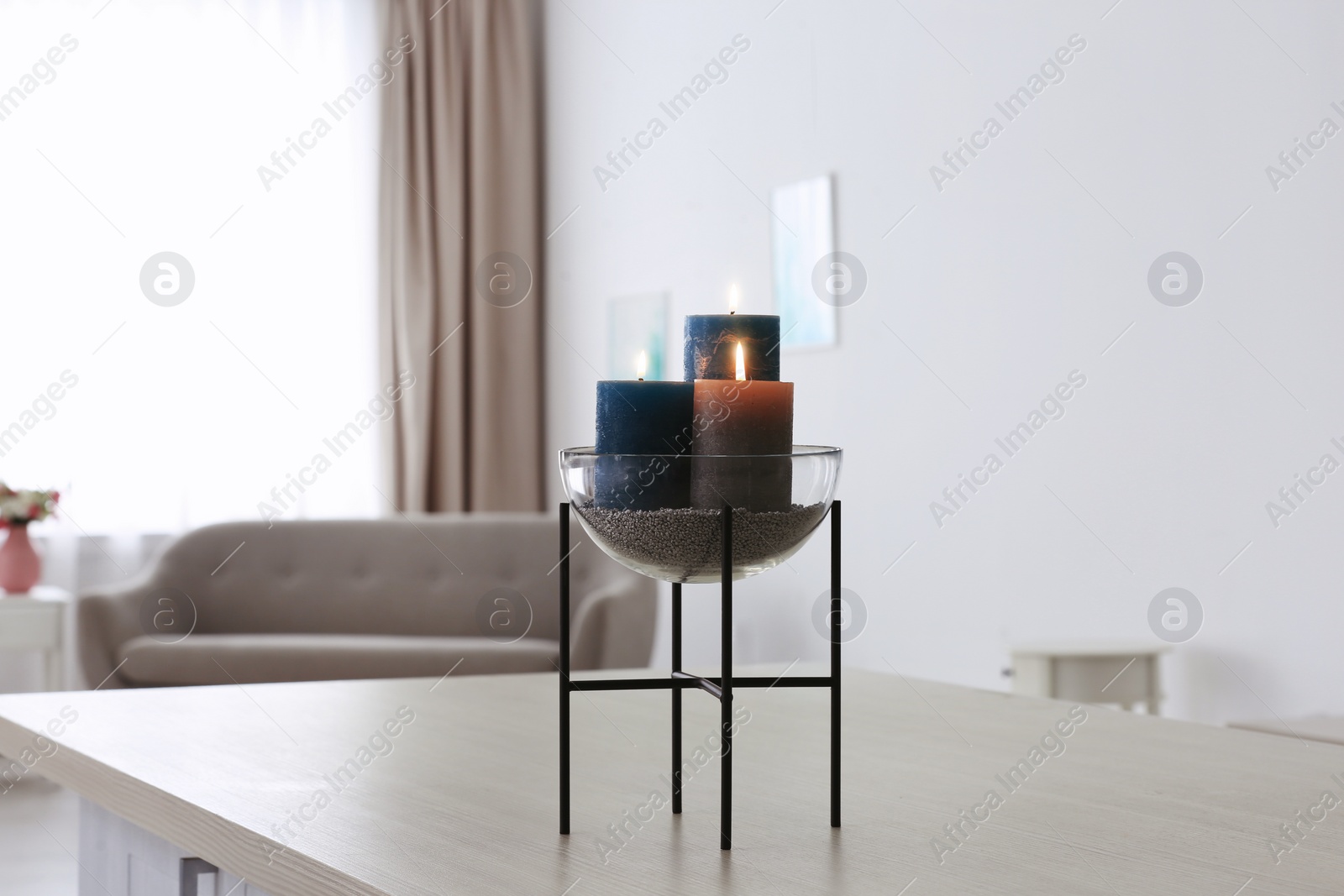 Photo of Burning candles on table in living room