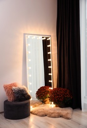 Full length dressing mirror with lamps in stylish room interior