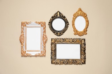 Photo of Empty vintage frames hanging on beige wall