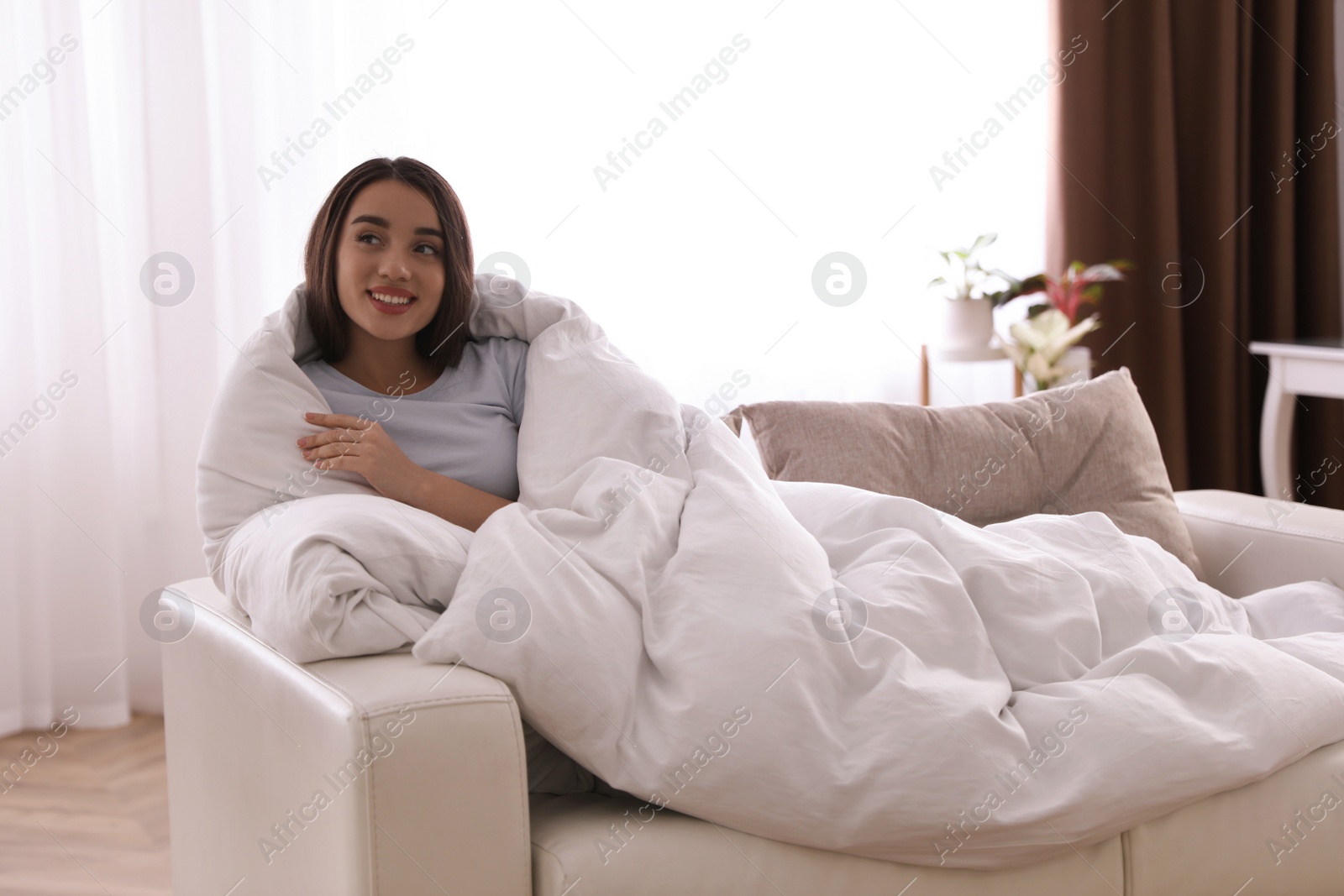 Photo of Woman covered in blanket resting on sofa, space for text