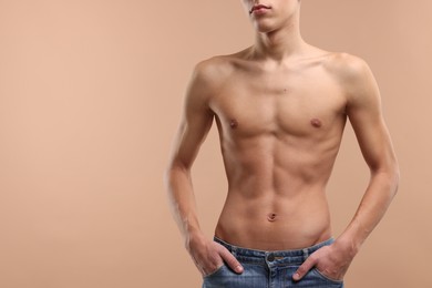 Shirtless man with slim body on beige background, closeup. Space for text