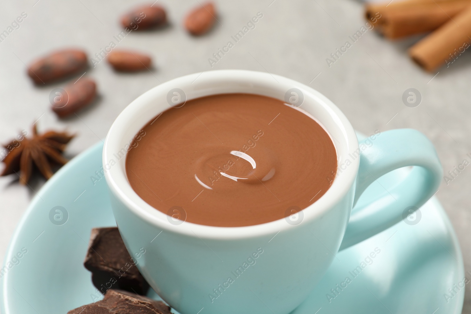 Photo of Yummy hot chocolate in cup on light grey table, closeup