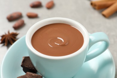 Yummy hot chocolate in cup on light grey table, closeup