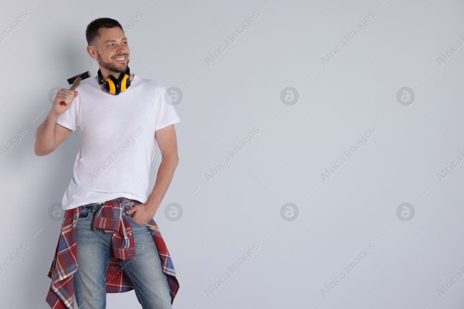 Photo of Handsome worker with hammer on white background, space for text