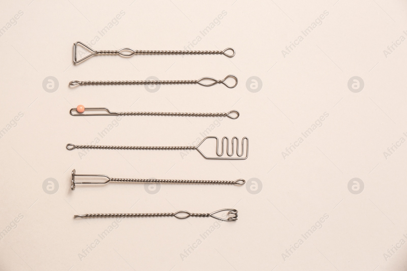 Photo of Set of logopedic probes for speech therapy on beige background, flat lay