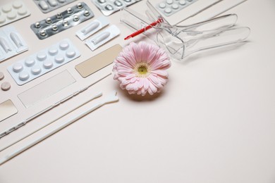 Sterile gynecological tools, pills and gerbera flower on beige background. Space for text