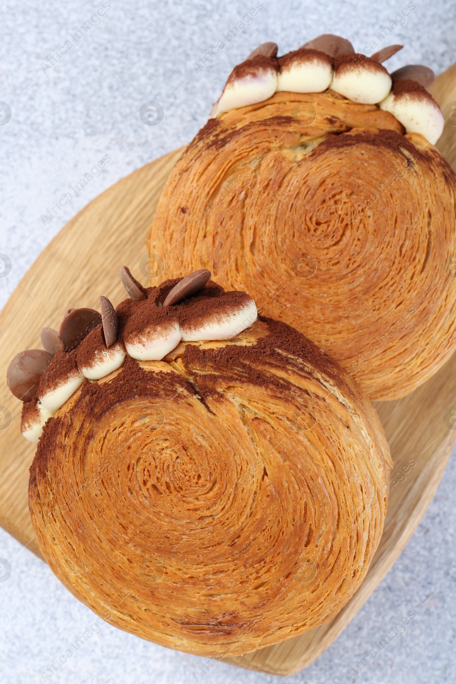 Photo of Supreme croissants with chocolate chips and cream on grey table, above view. Tasty puff pastry